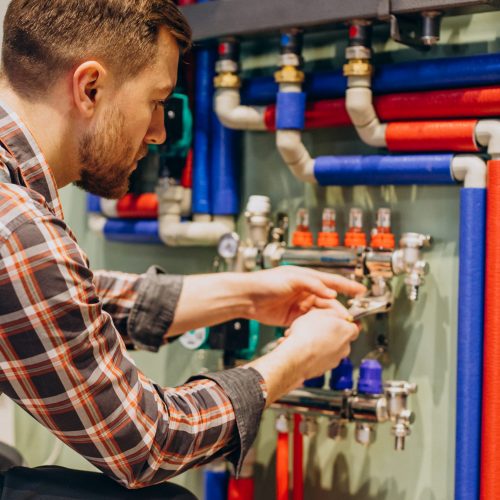 Young engineer adjusting autonomous heating Young engineer adjusting autonomous heating